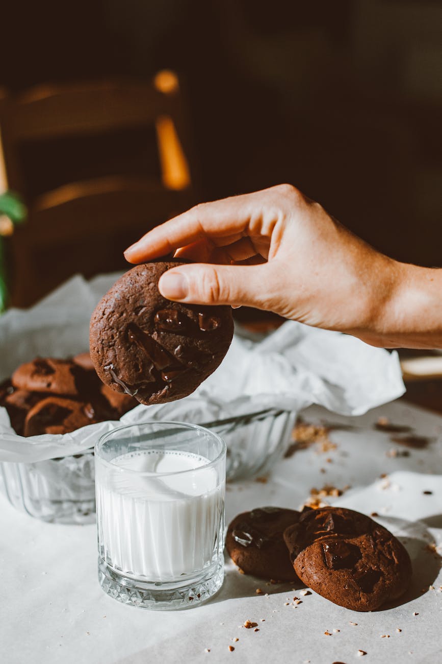 a person holding a chocolate cookie